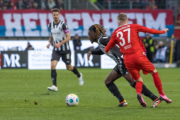 Football match, Manu KONE Borussia Moenchengladbach left on the ball, Jan-Niklas BESTE 1.FC Heidenheim right tries to stop him, in the background captain Julian WEIGL Borussia Moenchengladbach, football stadium Voith-Arena, Heidenheim