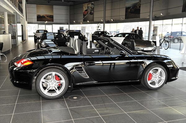 A black Porsche Boxster with red brake callipers presented at the dealership, Schwaebisch Gmuend, Baden-Wuerttemberg, Germany, Europe