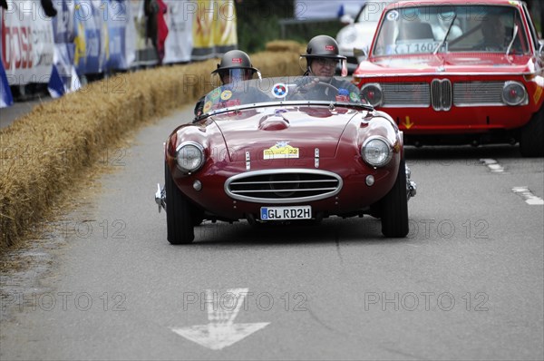 A red vintage convertible takes part in a race, surrounded by spectators, SOLITUDE REVIVAL 2011, Stuttgart, Baden-Wuerttemberg, Germany, Europe