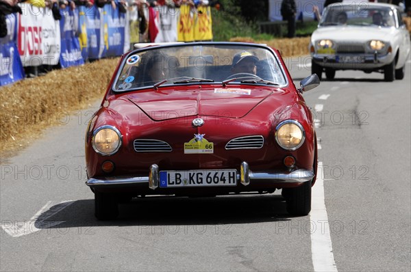 A red vintage sports car drives along in front of spectators during a street race, SOLITUDE REVIVAL 2011, Stuttgart, Baden-Wuerttemberg, Germany, Europe