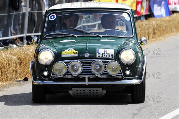 A green classic Mini Cooper in a street race surrounded by spectators, SOLITUDE REVIVAL 2011, Stuttgart, Baden-Wuerttemberg, Germany, Europe