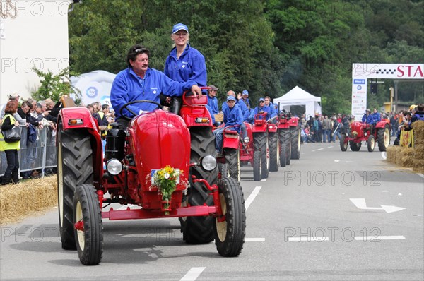 Porsche diesel tractors, Cheerful drivers drive red tractors in a parade in front of an audience, SOLITUDE REVIVAL 2011, Stuttgart, Baden-Wuerttemberg, Germany, Europe
