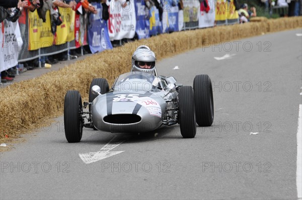 A silver historic racing car curves past bales of straw while spectators look on, SOLITUDE REVIVAL 2011, Stuttgart, Baden-Wuerttemberg, Germany, Europe