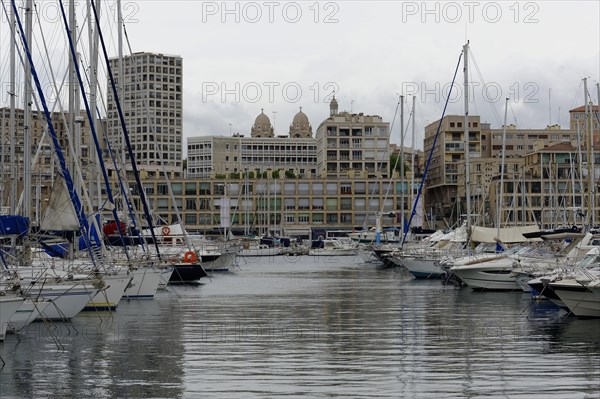 Marseille harbour, sailboats in the harbour with cloudy sky and urban scenery in the background, Marseille, Departement Bouches du Rhone, Region Provence Alpes Cote d'Azur, France, Europe