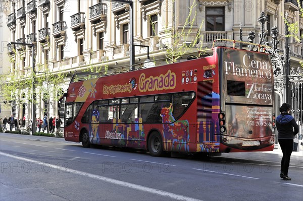 Granada, Colourful sightseeing double-decker bus in a busy city street, Granada, Andalusia, Spain, Europe