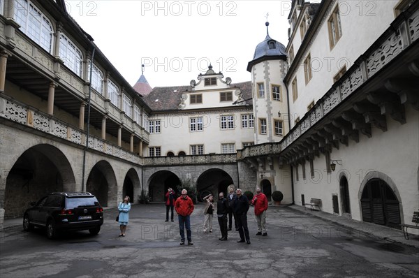 Langenburg Castle, People in the courtyard of a historic building with arched structures and a parked car, Langenburg Castle, Langenburg, Baden-Wuerttemberg, Germany, Europe
