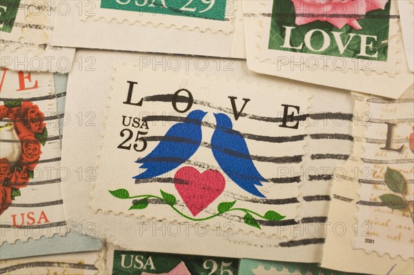 Close-up of old USA twenty five cent postage stamps with pair of blue doves, a red heart and green vine commemorating the theme of Love, Studio Composition, Quebec, Canada, North America