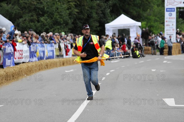 A person in a yellow safety waistcoat runs across a race track with a flag, SOLITUDE REVIVAL 2011, Stuttgart, Baden-Wuerttemberg, Germany, Europe