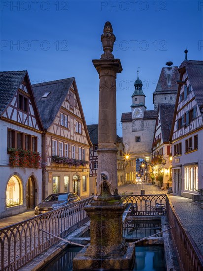 Roedergasse with Roederbrunnen, Markusturm and Roederbogen at dawn, Rothenburg ob der Tauber, Middle Franconia, Bavaria, Germany, Europe