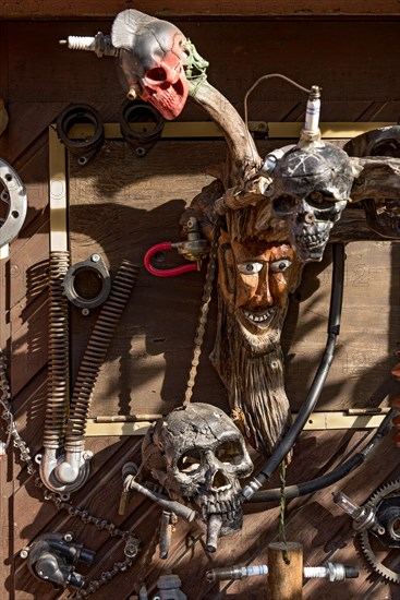 Old entrance door whimsically decorated, masks, skulls, engine parts, cartridge cases, tools, old town, Ortenberg, Vogelsberg, Wetterau, Hesse, Germany, Europe