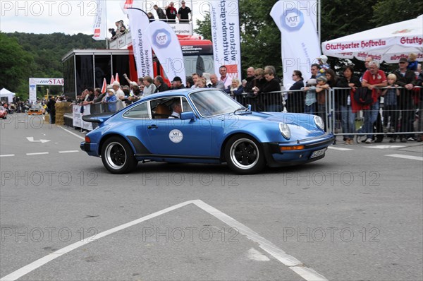 A blue classic car drives past a race while spectators watch, SOLITUDE REVIVAL 2011, Stuttgart, Baden-Wuerttemberg, Germany, Europe
