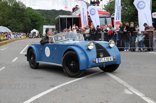 A blue vintage car drives past a street race with smiling spectators, SOLITUDE REVIVAL 2011, Stuttgart, Baden-Wuerttemberg, Germany, Europe