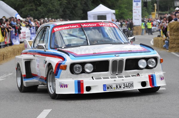 A classic BMW racing car in white, blue and red livery drives past spectators, SOLITUDE REVIVAL 2011, Stuttgart, Baden-Wuerttemberg, Germany, Europe