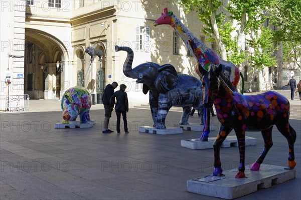 Colourful elephant sculptures on a square with people strolling in the background, Marseille, Departement Bouches-du-Rhone, Provence-Alpes-Cote d'Azur region, France, Europe