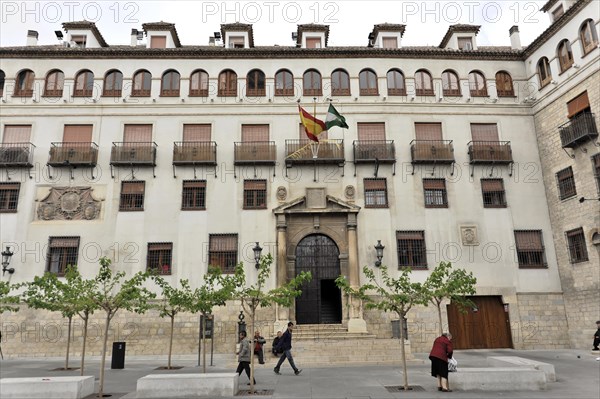 Jaen, Historic building with Spanish flag and newly planted trees in front of it, Jaen, Andalusia, Spain, Europe