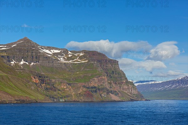 Rugged mountains and steep sea cliffs along the fjord Seyoisfjoerour, Seydisfjoerdur in summer, Eastern Region, Austurland, Iceland, Europe
