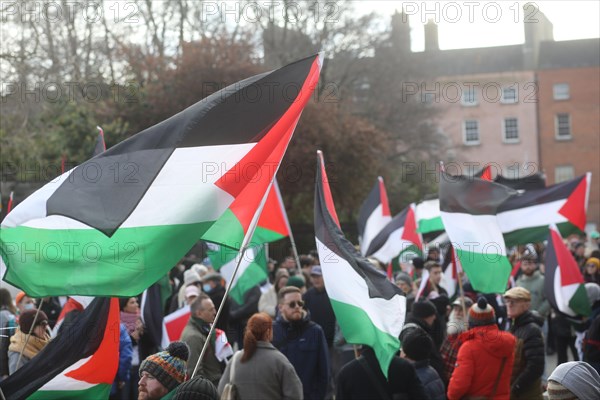 Palestine flags being held high in the air as a protest takes place against Israeli aggression in Gaza. Dublin, Ireland, Europe