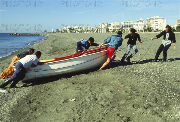 Fisherman pulling up boat on the beach in Torre del Mar, Malaga province, Costa del Sol, Andalusia, Mediterranean Sea, Spain, Southern Europe. Scanned thumbnail slide, Europe