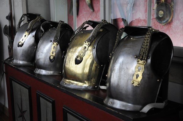 Langenburg Castle, row of shiny metal helmets with chains on a red surface, Langenburg Castle, Langenburg, Baden-Wuerttemberg, Germany, Europe