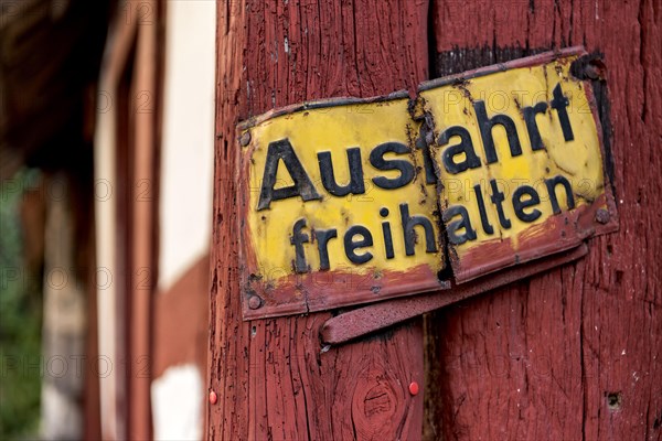 Old sign, keep exit clear, bent and rusty on wooden beam, courtyard exit, historic half-timbered house, old town, Ortenberg, Vogelsberg, Wetterau, Hesse, Germany, Europe