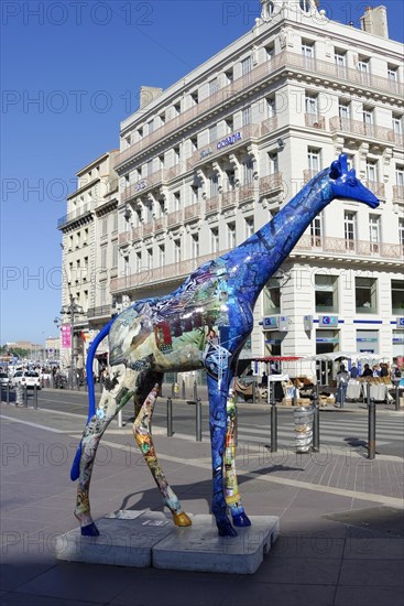 Colourful giraffe sculpture on a busy city street, Marseille, Departement Bouches-du-Rhone, Provence-Alpes-Cote d'Azur region, France, Europe
