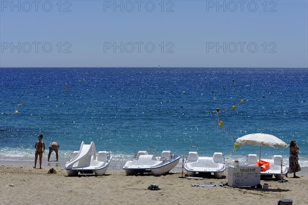 The bay of Port Miou in Cassis, A sunny beach day with people, sunbathing boats and clear blue sea, Marseille, Departement Bouches-du-Rhone, Region Provence-Alpes-Cote d'Azur, France, Europe