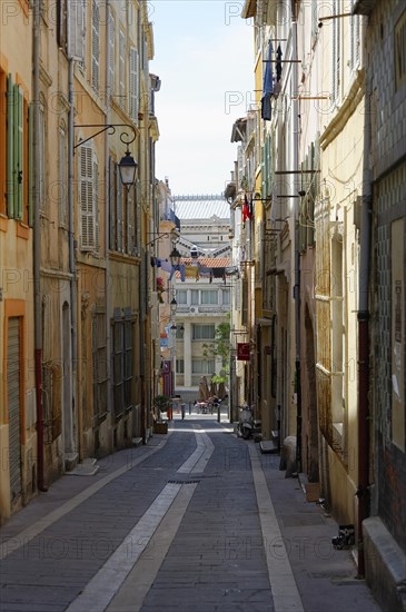 Marseille, Narrow street flanked by traditional buildings and lanterns in daylight, Marseille, Departement Bouches-du-Rhone, Region Provence-Alpes-Cote d'Azur, France, Europe