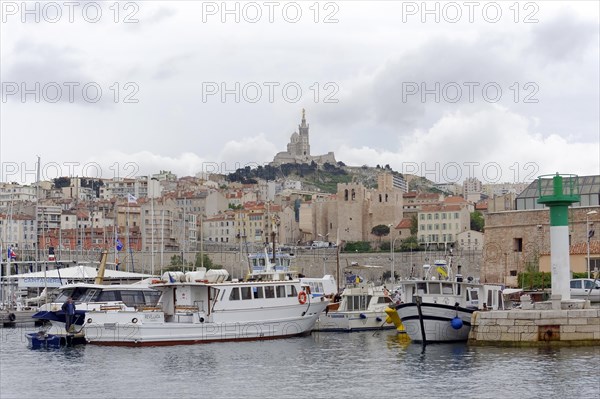 Marseille, view of a harbour with boats and the city in the background under a cloudy sky, Marseille, Departement Bouches du Rhone, Region Provence Alpes Cote d'Azur, France, Europe
