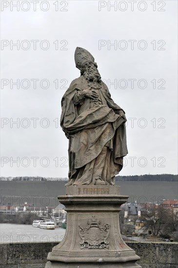 Saint Fridericus statue on the old Main bridge, Wuerzburg, stone statue of a bishop on a pedestal with a bridge in the background, Wuerzburg, Lower Franconia, Bavaria, Germany, Europe