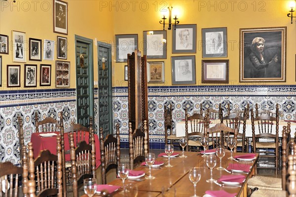 Jaen, Empty restaurant with tables, chairs and portraits on wall tiles, Jaen, Andalusia, Spain, Europe