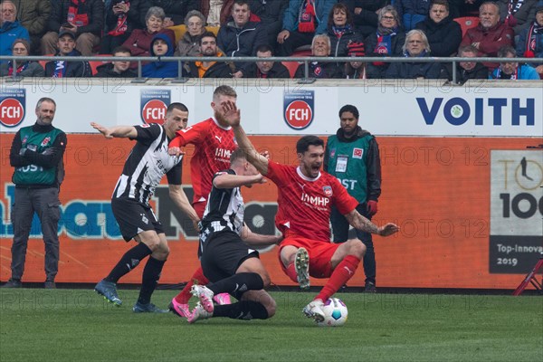 Football match, Robin HACK Borussia Moenchengladbach centre left fouls Tim KLEINDIENST 1.FC Heidenheim who falls down visibly in pain, in the background Stefan LAINER Borussia Moenchengladbach left and Jan-Niklas BESTE 1.FC Heidenheim, football stadium Voith-Arena, Heidenheim