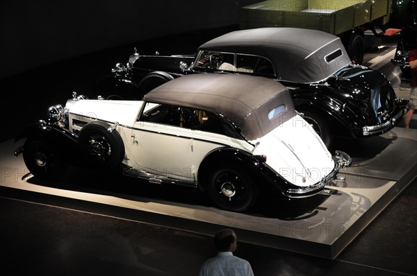 Two luxurious vintage cars in black and white under artificial light, Mercedes-Benz Museum, Stuttgart, Baden-Wuerttemberg, Germany, Europe