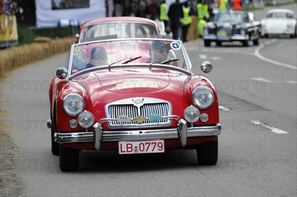 A red MG vintage convertible drives on a road at a racing event, SOLITUDE REVIVAL 2011, Stuttgart, Baden-Wuerttemberg, Germany, Europe
