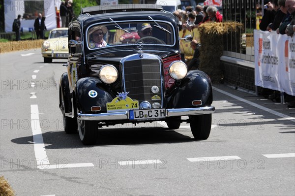 A classic Mercedes vintage car drives past spectators at a sunny road race, SOLITUDE REVIVAL 2011, Stuttgart, Baden-Wuerttemberg, Germany, Europe
