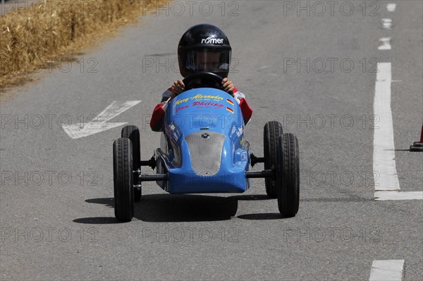 A child rides a blue soapbox in a race on a street, SOLITUDE REVIVAL 2011, Stuttgart, Baden-Wuerttemberg, Germany, Europe