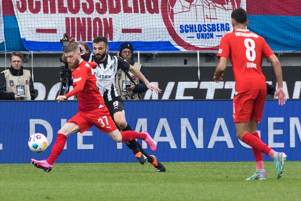 Football match, Jan-Niklas BESTE 1.FC Heidenheim left takes a shot, Franck HONORAT Borussia Moenchengladbach tries to stop him, Eren DINKCI 1.FC Heidenheim right watches the scene, Voith-Arena football stadium, Heidenheim