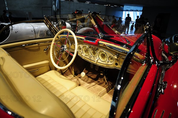 View into the cockpit of a classic red vintage car with stylish steering wheel and fittings, Mercedes-Benz Museum, Stuttgart, Baden-Wuerttemberg, Germany, Europe