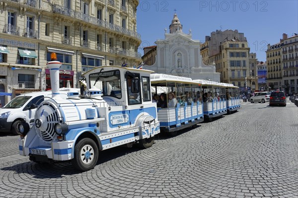 Marseille, A blue and white tourist train passes in front of a church with passengers on board, Marseille, Departement Bouches-du-Rhone, Region Provence-Alpes-Cote d'Azur, France, Europe
