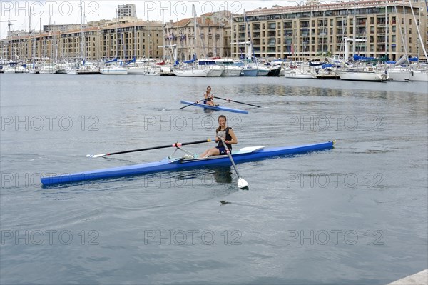 Marseille harbour, Two rowers in a rowing boat in a harbour area, Marseille, Departement Bouches-du-Rhone, Region Provence-Alpes-Cote d'Azur, France, Europe