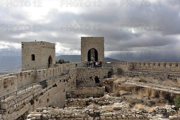 Castillo de Santa Catalina on Jaen, Historic fortress with towers and visitors on the ruins with cloudy sky in the background, Granada, Andalusia, Spain, Europe