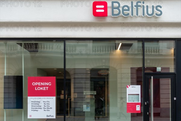 Office window showing opening hours of Belfius bank branch in the city Ghent, East Flanders, Belgium, Europe