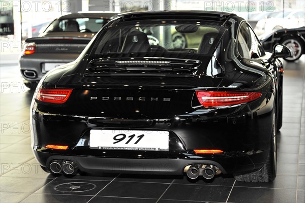 Rear view of a black Porsche 911 sports car in a showroom, Schwaebisch Gmuend, Baden-Wuerttemberg, Germany, Europe