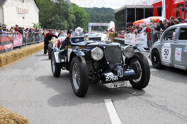 A black classic racing car is surrounded by spectators at the starting line, SOLITUDE REVIVAL 2011, Stuttgart, Baden-Wuerttemberg, Germany, Europe
