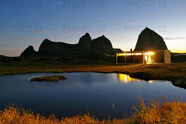 Striking rocks, small lake and tourist accommodation, Lovunden, Helgeland coast, Traena, Norway, Europe