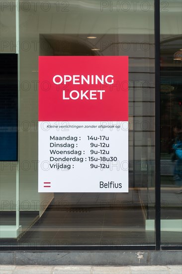 Office window showing opening hours of Belfius bank branch in the city Ghent, East Flanders, Belgium, Europe