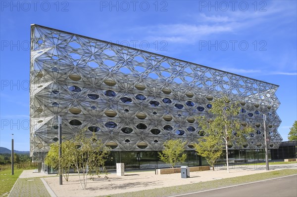 Reutlingen University, Reutlingen University, Texoversum, German University Building Award 2024 for TEXOVERSUM, modern architecture, facade made of carbon and glass fibres, mesh, innovative, identity-creating, unique facade, campus, place of learning, special, extraordinary new building for textile courses, light, airy, airy, holes, architectural eye-catcher, university campus, lights, street, young trees, blue sky, Reutlingen, Baden-Wuerttemberg, Germany, Europe