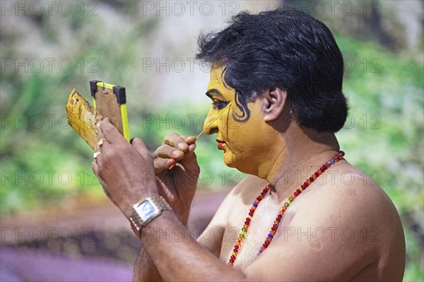 Kathakali performer or mime, 60 years old, makes up his face, Kochi Kathakali Centre, Kochi, Kerala, India, Asia