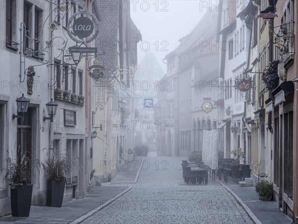 Street with town houses in the historic old town in the morning fog, Rothenburg ob der Tauber, Middle Franconia, Bavaria, Germany, Europe