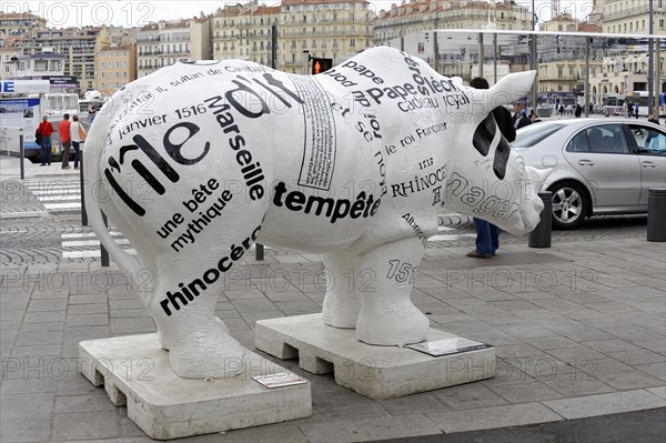 Marseille, A rhinoceros sculpture covered with headlines on a pavement in the city, Marseille, Departement Bouches du Rhone, Region Provence Alpes Cote d'Azur, France, Europe