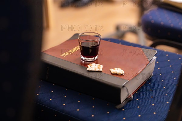 A Bible lies next to a filled glass on a table with a blue tablecloth, Bible Circle, Jesus Grace Chruch, Ludwigsburg, Germany, Europe